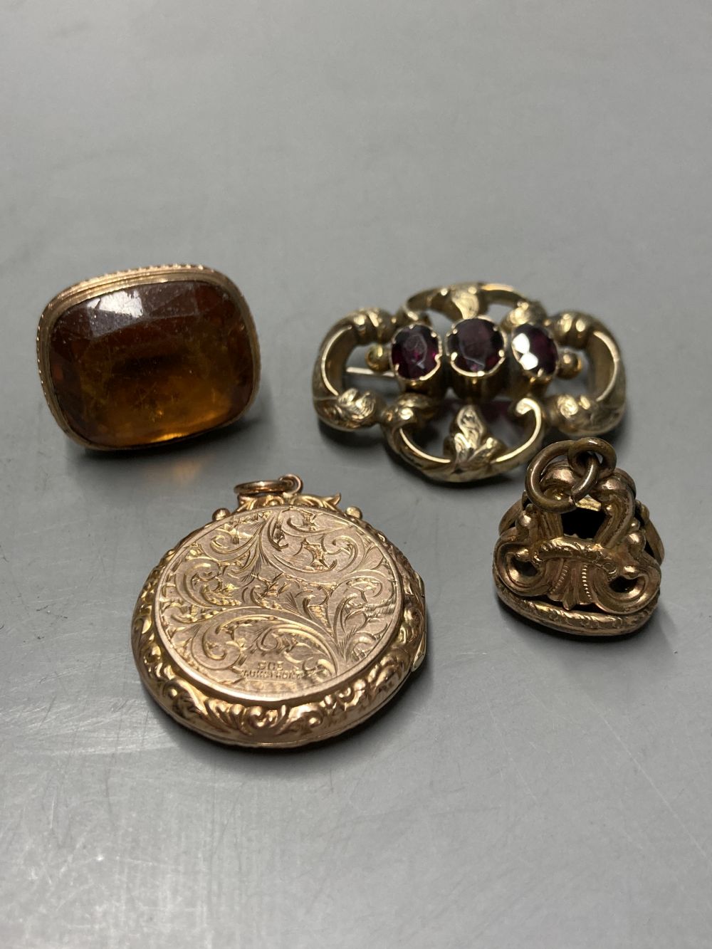 Two gold plated overlaid and gem set fob seals, largest 35mm, a 9ct front and back locket and a scroll brooch.